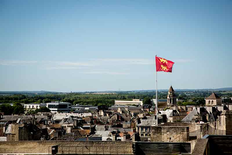 Die Flagge der Normandie mit den Löwen – einer weniger als England, aber dennoch gleichen Ursprungs – auf den Mauern der Burg über Caen