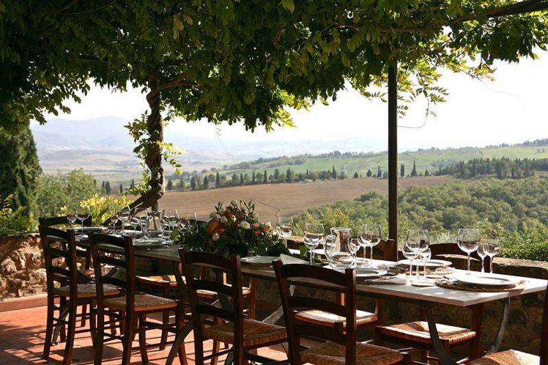 Ein gedeckter Tisch und der Blick ins Land - so sieht der kulinarische Traum Italien aus! | © stock.adobe by Julia Kostina